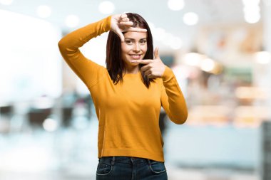 El ile çerçeve şekil verme kadın bir kafeterya kamera sanki gibi odaklanmaya çalışıyor genç güzel