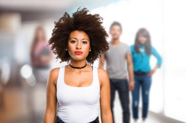 arka plan bulanık insanlarla duran genç siyah kadın