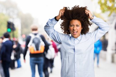 Genç siyah kadının arka plan bulanık deli jest yapması