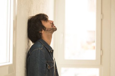 Genç yakışıklı adam neşeli ve kendine güvenen ayakta pencere kapalı karşı 