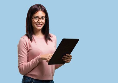 Gülümseyen ve kendinden emin, genç güzel kadın bir tablet için kullanarak internette sörf tutup bkz: sosyal ağlar, iletişim kavramı