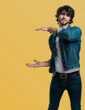 Elleriyle bir şey tutan, bir ürün, gülümseyen ve neşeli gösterilen, hayali bir nesne sunan yakışıklı delikanlı