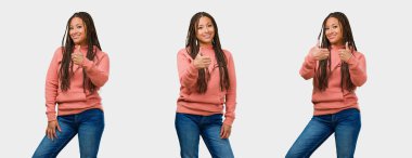 Fitness genç siyah kadın neşeli ve heyecanlı kümesi, gülümseyerek ve onu yetiştirme kadar gri arka plan üzerinde parmak