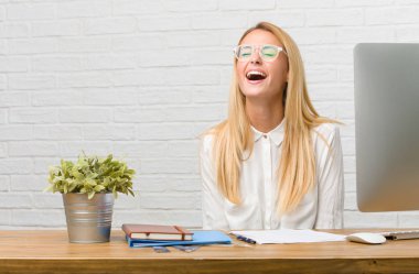 Kendinden emin ve başarılı portre rahat ve neşeli, gülen ve having fun, görevleri yapmak onun masasına oturan genç bir öğrenci hissediyor