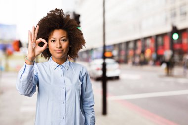 Genç siyah kadının arka plan bulanık iyi jest yapması