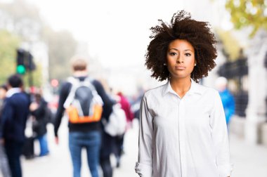 bulanık arka plan üzerinde duran genç siyah kadın