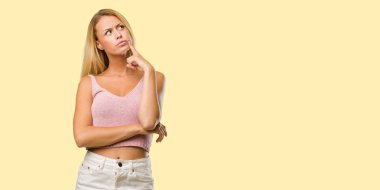 Düşünme ve ararken genç güzel sarışın kadın portresi