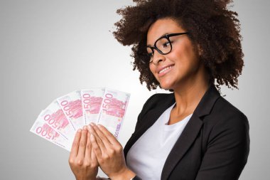 faturaları gri arka plan üzerinde tutan siyah kadın