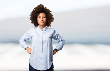 bulanık arka plan üzerinde duran genç siyah kadın