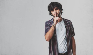 Genç yakışıklı bir sırrı saklamak veya soran sessizlik, ciddi bir yüz, itaat kavramı için adam