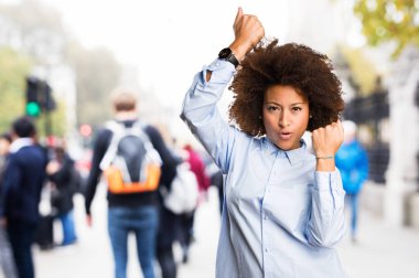 Genç siyah kadının arka plan bulanık kazanan jest yapması