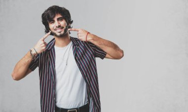 Genç yakışıklı adam gülümsüyor, ağız, işaret kavramının mükemmel dişler, beyaz dişler, neşeli ve neşeli bir tutum yoktur