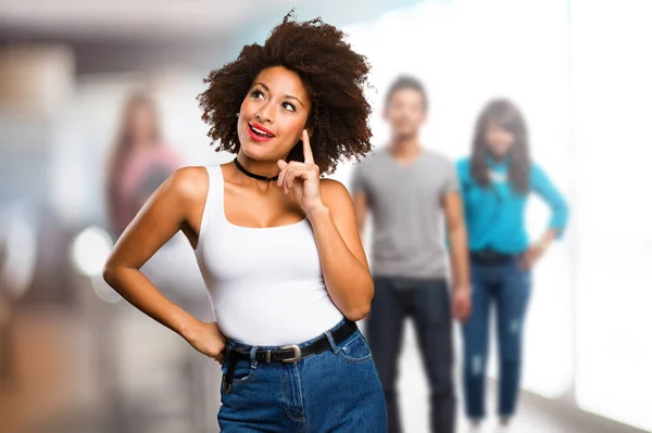 young black woman thinking with blurred people in background