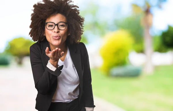 black business woman sending kisses on blurred background