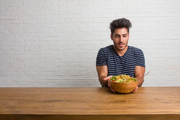 Joven Hombre Guapo Natural Sentado Una Mesa Sosteniendo Algo Con — Foto de Stock