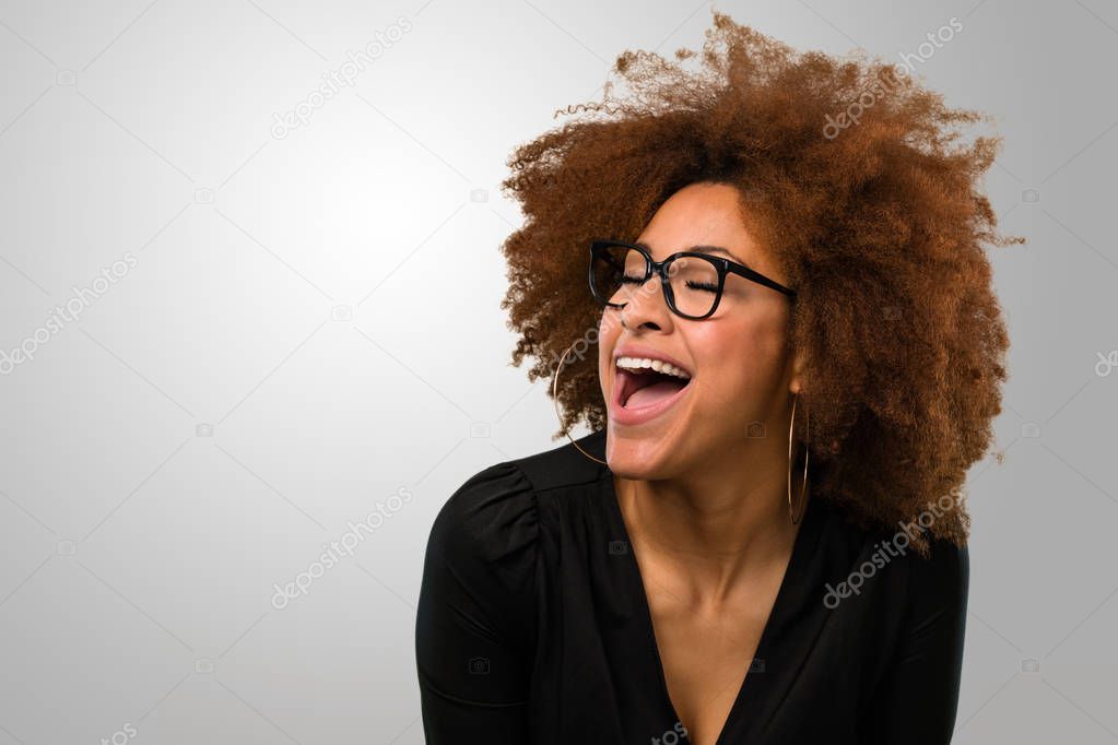 Afro woman laughing happy wearing glasses