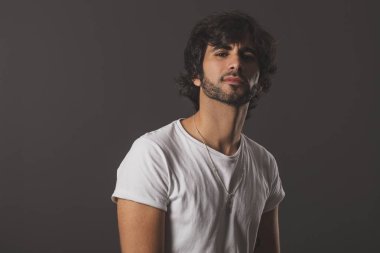 Genç yakışıklı adam neşeli ve kendine güvenen Studio kamera bakıyor 