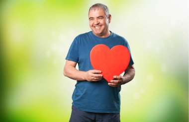 bir kalp şekli tutan olgun adam