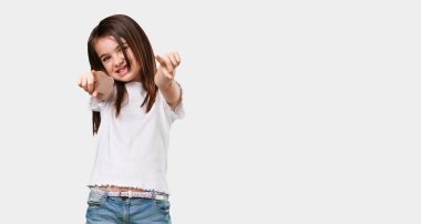 Tam vücut küçük kız neşeli ve gülümseyerek önüne işaret