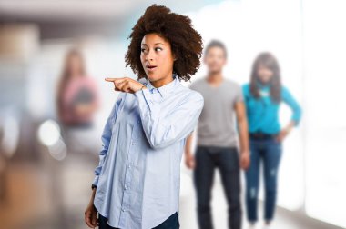 alan arka plan bulanık insanlarla işaret eden genç siyah kadın