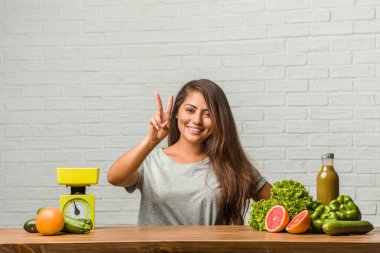 Diyet kavramı. Sağlıklı genç bir latin kadın gösterilen iki numaralı sayma simgesi, matematik, kendinden emin ve neşeli kavramı portresi