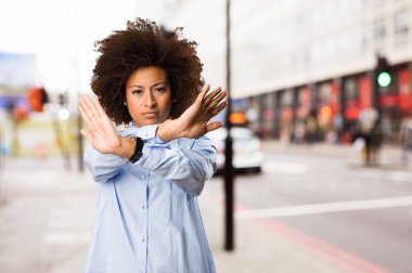 Genç siyah kadının arka plan bulanık dur jest yapması