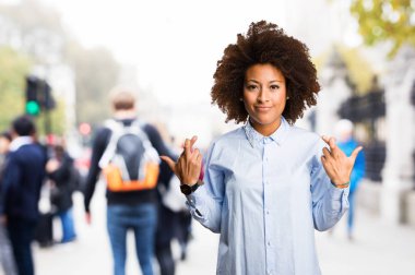 Genç siyah kadının arka plan bulanık iyi şanslar jest yapması