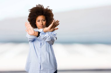 Genç siyah kadının arka plan bulanık dur jest yapması