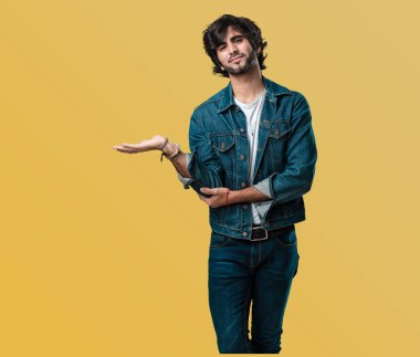 Elleriyle bir şey tutan, bir ürün, gülümseyen ve neşeli gösterilen, hayali bir nesne sunan yakışıklı delikanlı