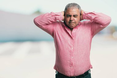 Eller, kızgın ve bazı ses işitme yorgun kulaklarıyla kapsayan orta yaşlı adam