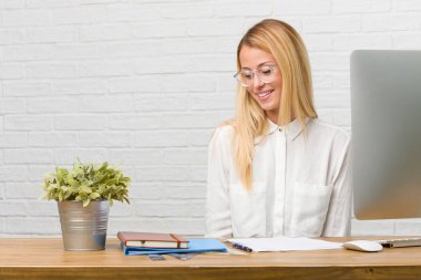 Kendinden emin ve başarılı portre rahat ve neşeli, gülen ve having fun, görevleri yapmak onun masasına oturan genç bir öğrenci hissediyor