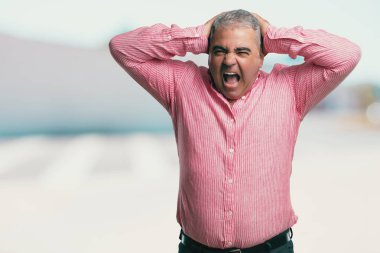 Orta yaşlı adam sinirli ve umutsuz, kızgın ve üzgün başında elleriyle