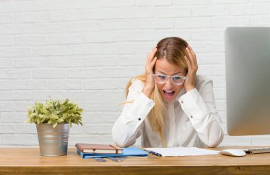 Görevleri sinirli ve umutsuz, kızgın ve üzgün ile yapmak masasına oturan genç öğrenci portresi ellerinizi başınızın koyun