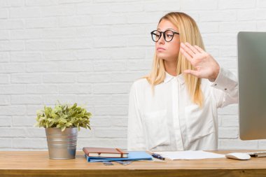 Görevleri ciddi ve kararlı, önde, el koyarak yapmak onun masanın üzerinde dur jest, oturan genç öğrenci portresi inkar kavramı