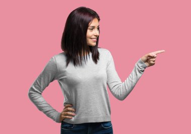 Sürpriz bir şey, doğal ve rahat sunan gülümseyen tarafına işaret eden genç güzel kadın