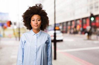 bulanık arka plan üzerinde duran genç siyah kadın