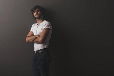 Genç yakışıklı adam neşeli ve kendine güvenen Studio kamera bakıyor 