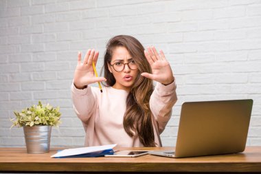 Ciddi ve kararlı masada oturan genç öğrenci latin kadın portresi