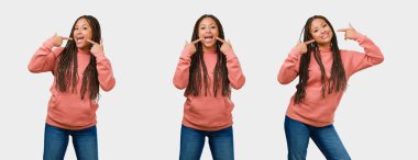 Dizi fitness genç siyah kadın gülümsüyor, işaretleme ağız, mükemmel dişleri gri arka plan üzerinde kavramı