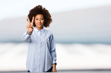 Genç siyah kadının üzerinde ikinci bir jest yapması arka plan bulanık