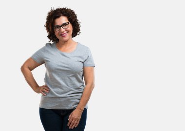 Kalça, ayakta, rahat ve gülümseyen, çok olumlu ve neşeli ellerinde olan orta yaşlı kadın