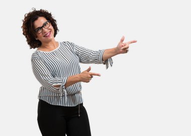 Sürpriz bir şey, doğal ve rahat sunan gülümseyen tarafına işaret orta yaşlı kadın