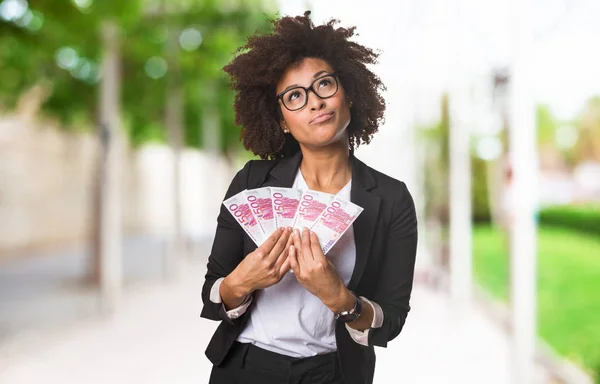 背景をぼかした写真に紙幣を保持している黒のビジネス女性 — ストック写真
