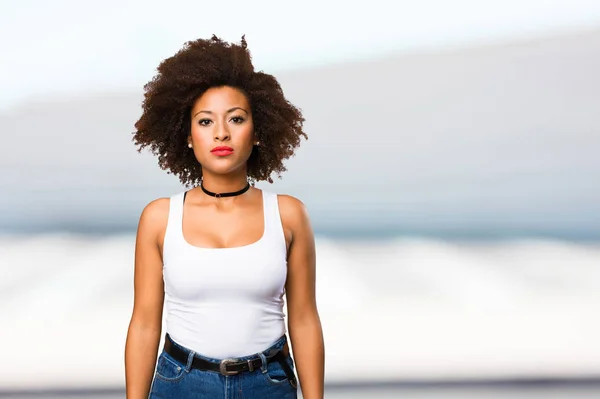 Bulanık Arka Plan Üzerinde Duran Genç Siyah Kadın — Stok fotoğraf