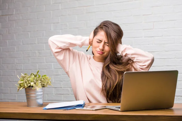 Elleriyle kulaklarını kapsayan masasında oturan genç öğrenci latin kadın portresi