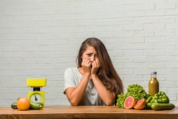 Diyet kavramı. Portre sağlıklı genç bir latin kadın ısırma, çivi, gergin ve çok endişeli ve gelecek için korkmuş hissediyor panik ve stres