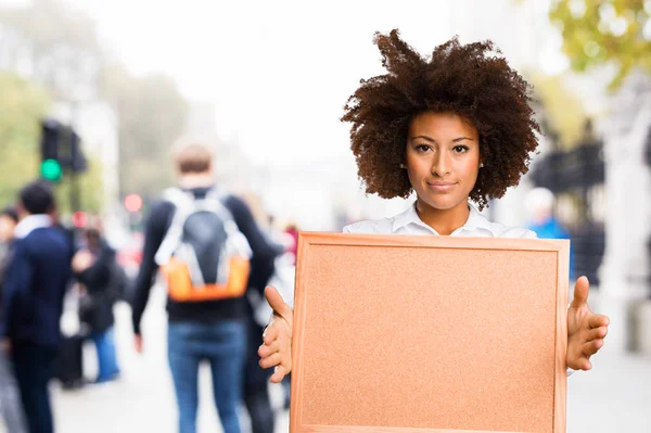 Young Black Woman Holding Cork Board Blurred Background — Stock Photo, Image