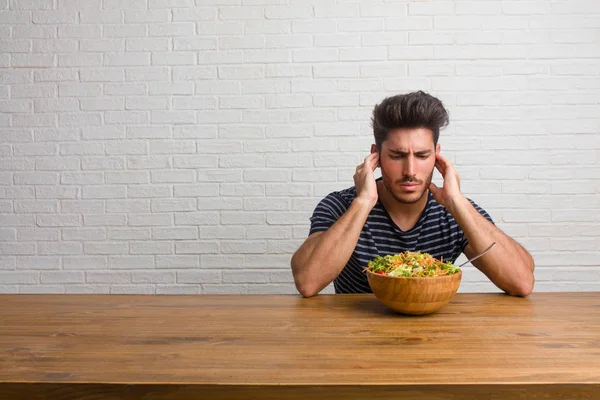 Joven Hombre Guapo Natural Sentado Una Mesa Cubriendo Las Orejas — Foto de Stock