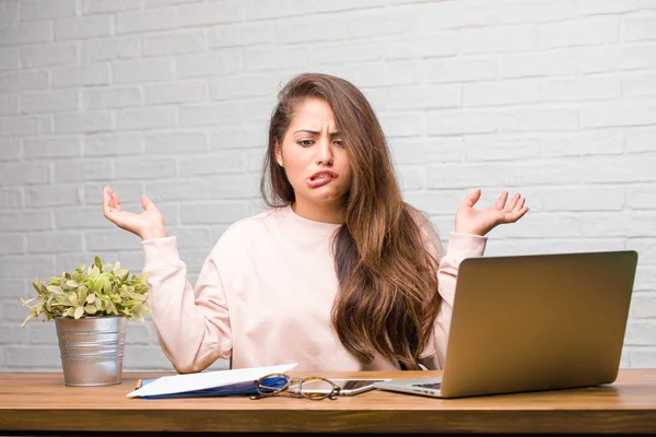 Çılgın ve umutsuz masanın üzerinde oturan genç öğrenci latin kadın portresi