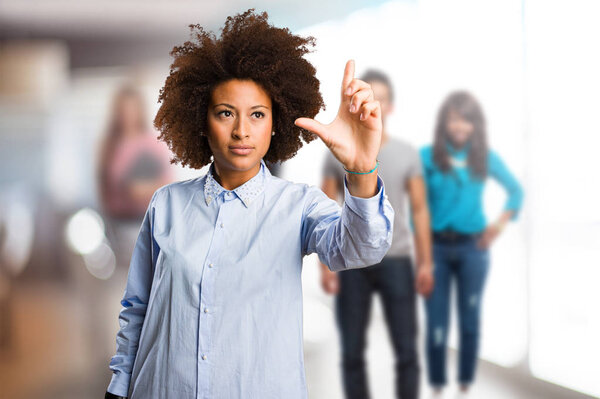 young black woman touching screen with blurred people in background